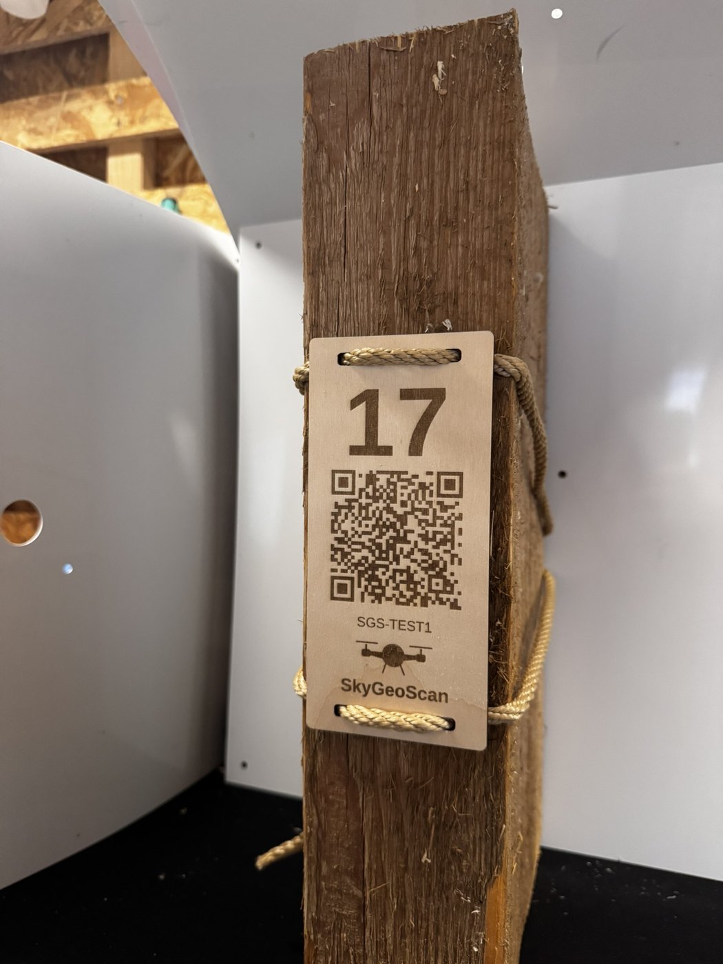 Holzschild mit Bauteilnummer 17 und QR-Code, mit Naturseil zerstörungsfrei am Balken befestigt