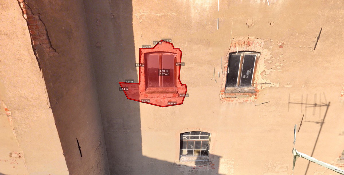 Drohnen-Punktwolke einer Putzfassade mit rot markiertem Schadensbereich am Fenstergewände inklusive Maßangaben